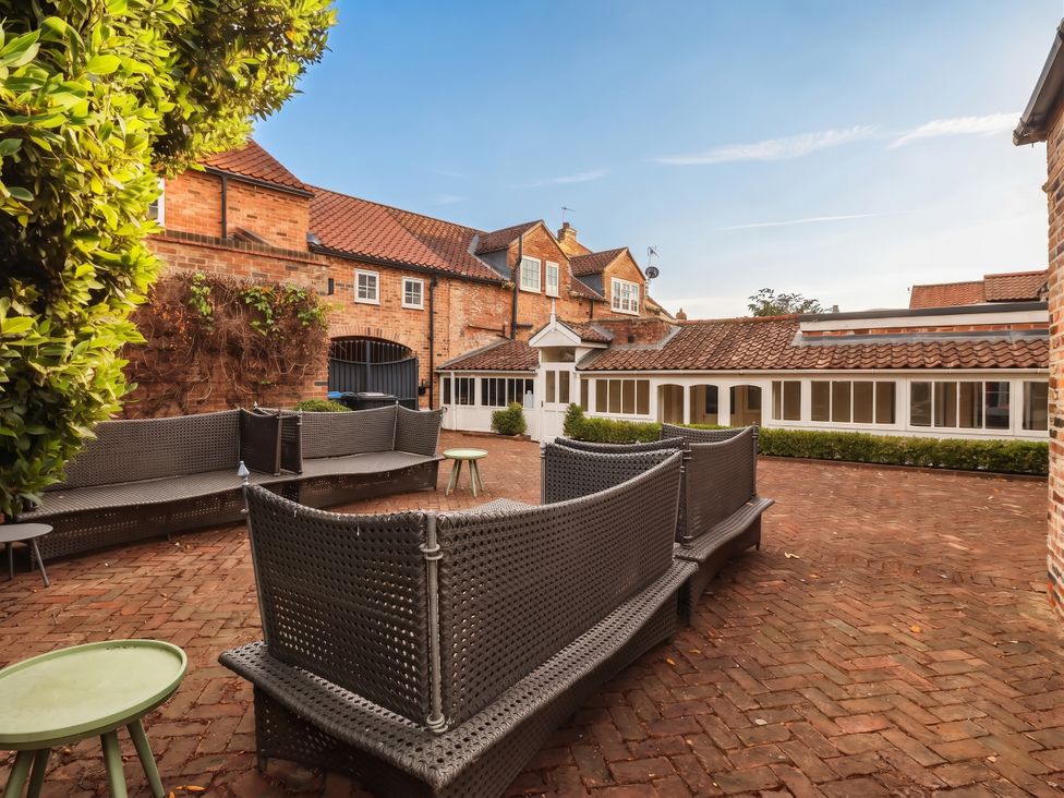 An outdoor courtyard with seating and brick walls at Cadogan House Easingwold