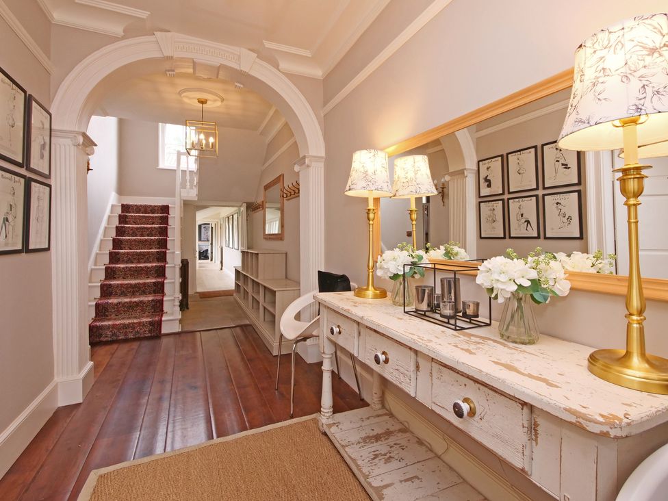 A hallway with stairs and a table at Cadogan House Easingwold