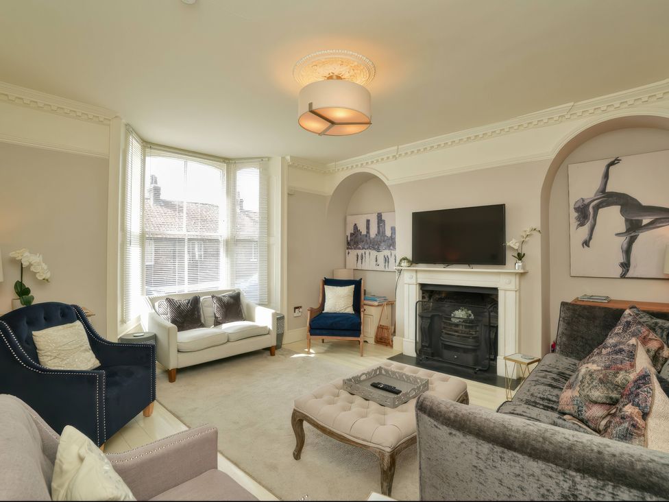 A living room with sofas and a television at Cadogan House Easingwold