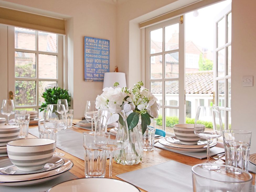 A dining room with a table set for dinner at Cadogan House in Easingwold