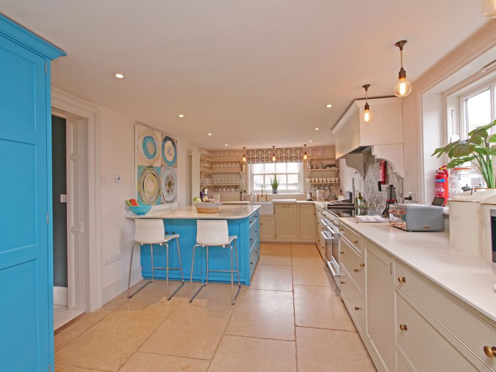 A kitchen with an island and bar stools at Cadogan House Easingwold