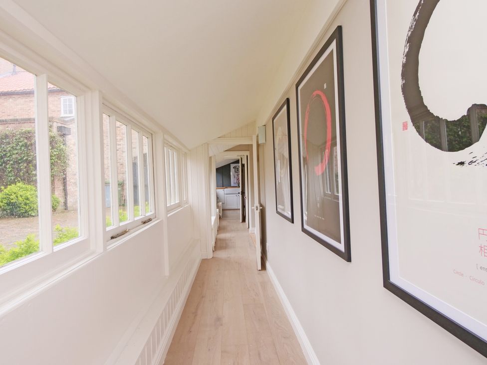 A hallway with art pieces on the walls at Cadogan House in Easingwold