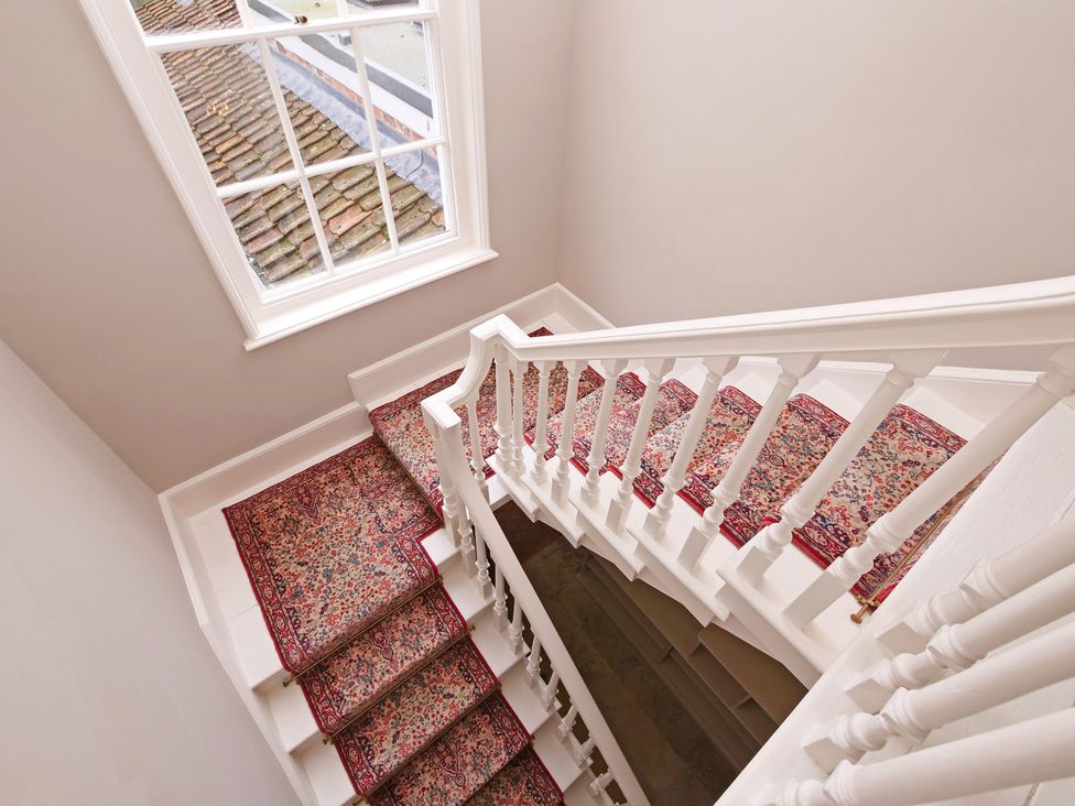 A staircase with carpet and a window at Cadogan House in Easingwold