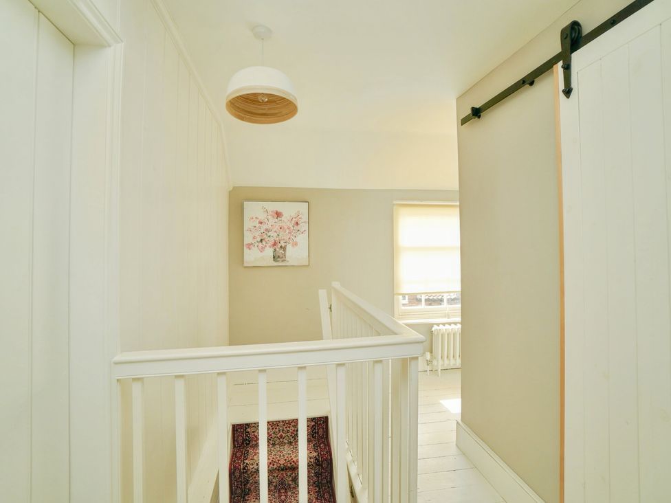 A hallway with a staircase and a painting at Cadogan House in Easingwold