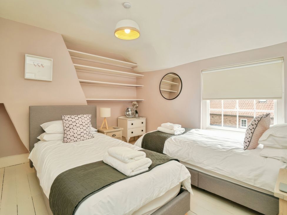 A bedroom with two beds and a window at Cadogan House Easingwold