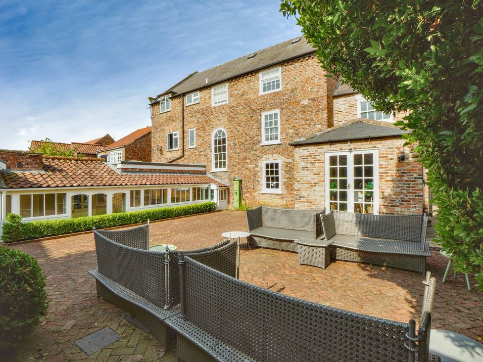 An outdoor area with seating and a brick pathway at Cadogan House Easingwold