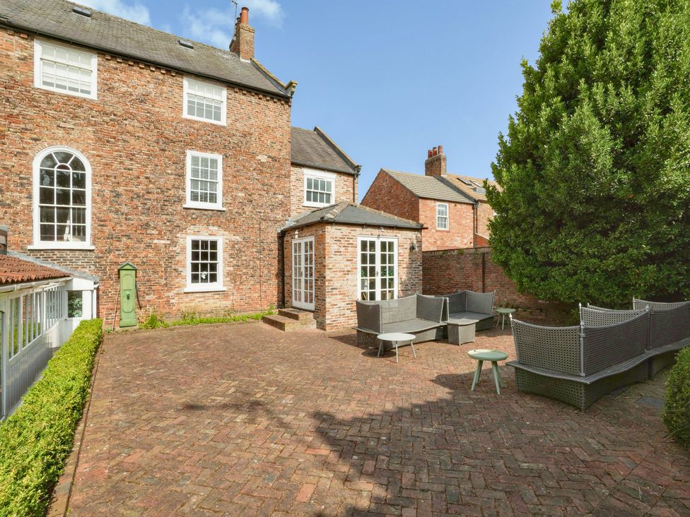 An outdoor area with garden furniture and a brick wall at Cadogan House Easingwold