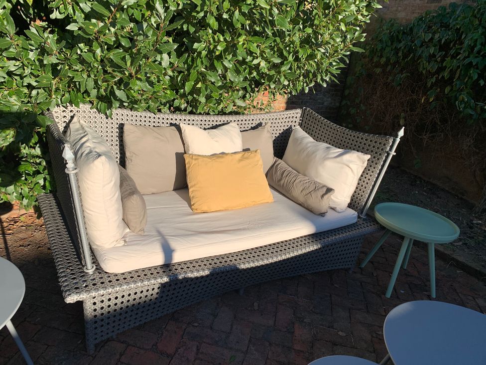 A sofa with cushions and a small table in a garden at Cadogan House Easingwold