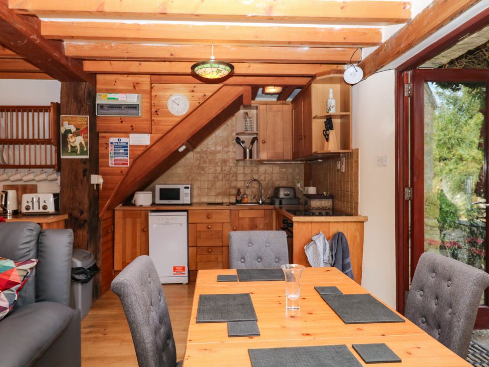 A kitchen with dining table and appliances at Dashel Cottage at Dockwell Farm near Widecombe-In-The-Moor