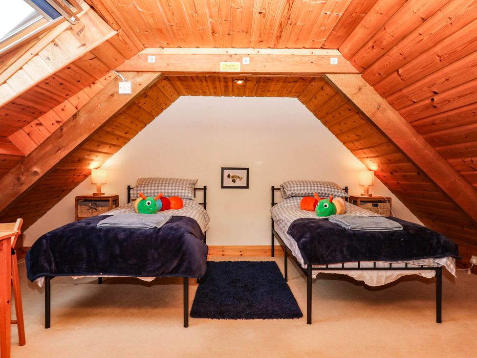 A bedroom with two beds and a rug at Dashel Cottage at Dockwell Farm near Widecombe-In-The-Moor