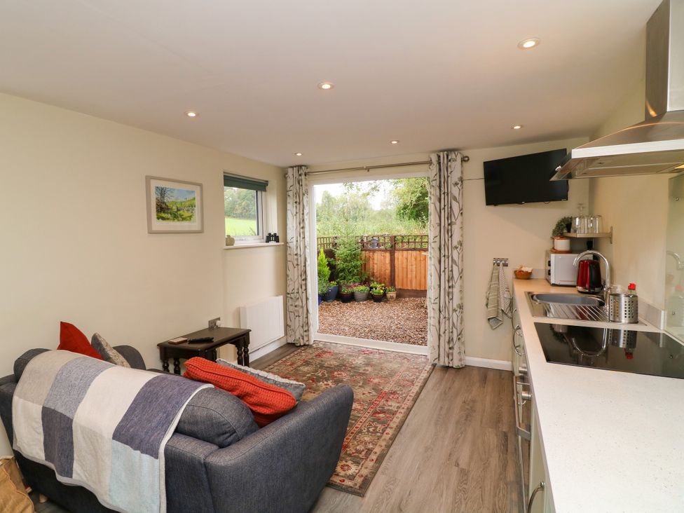 A living room with a sofa and television at Lodgeview Nottingham