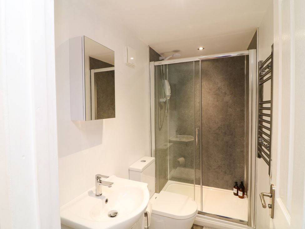 A bathroom with a shower and washbasin at Lodgeview Nottingham