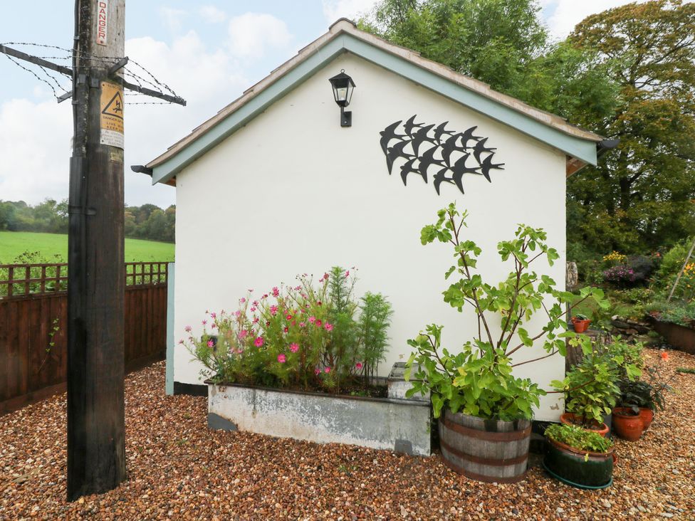 An outdoor view of a house with flower beds and a lamp at Lodgeview Nottingham