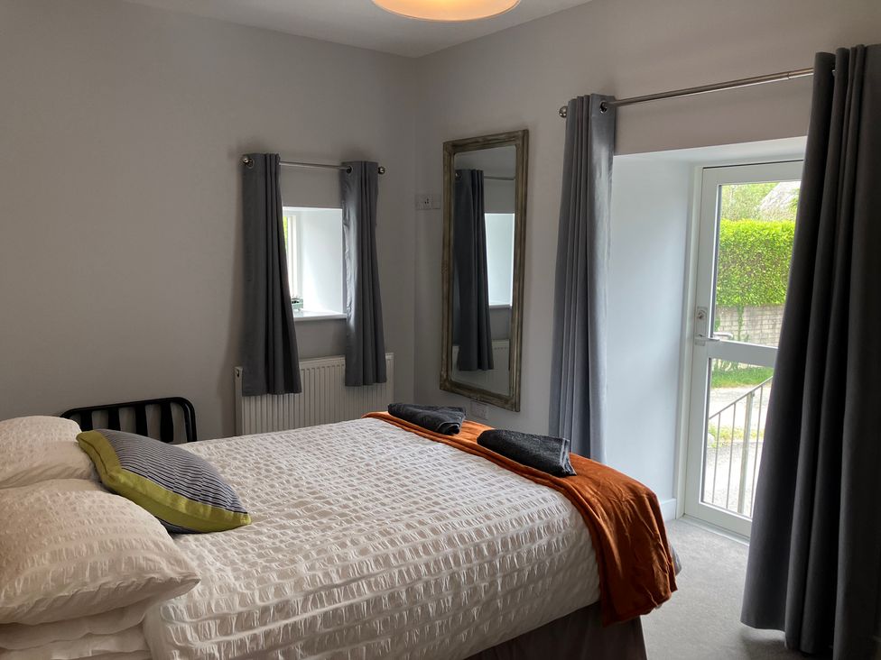 A bedroom with a bed and window at The Old Dairy near Liskeard
