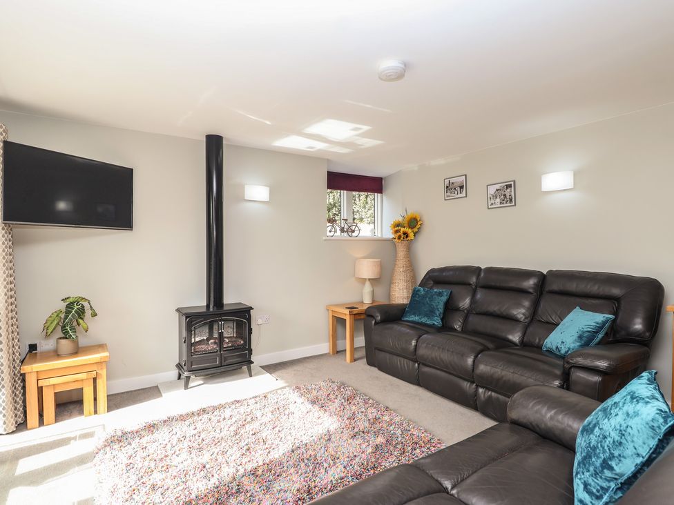 A living room with a television and sofa at The Old Dairy near Liskeard