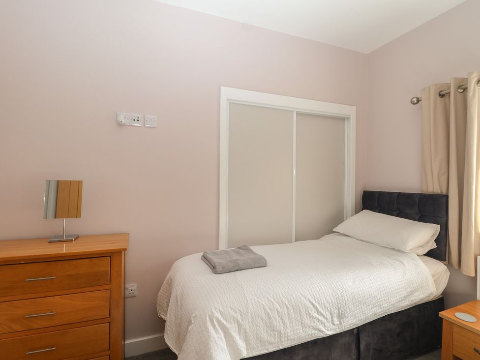 A bedroom with a bed and a dresser at The Old Dairy near Liskeard