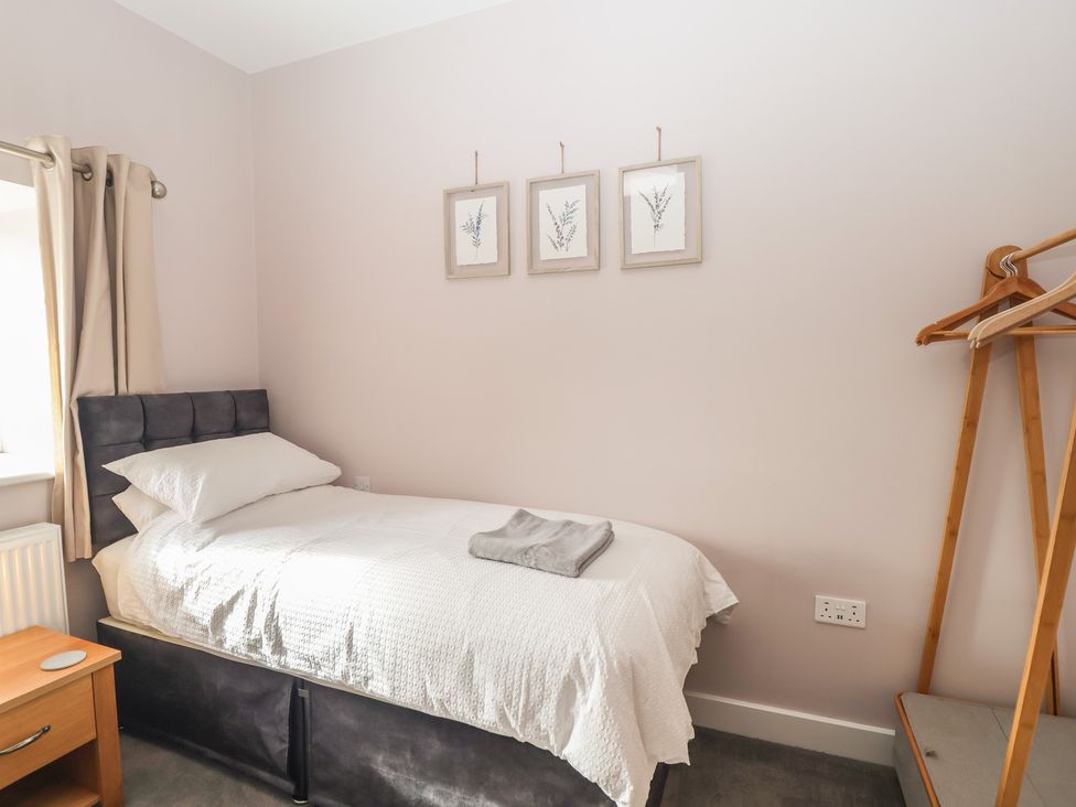 A bedroom with a single bed and a side table at The Old Dairy near Liskeard