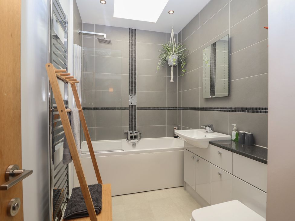 A bathroom with a bathtub and sink at The Old Dairy near Liskeard