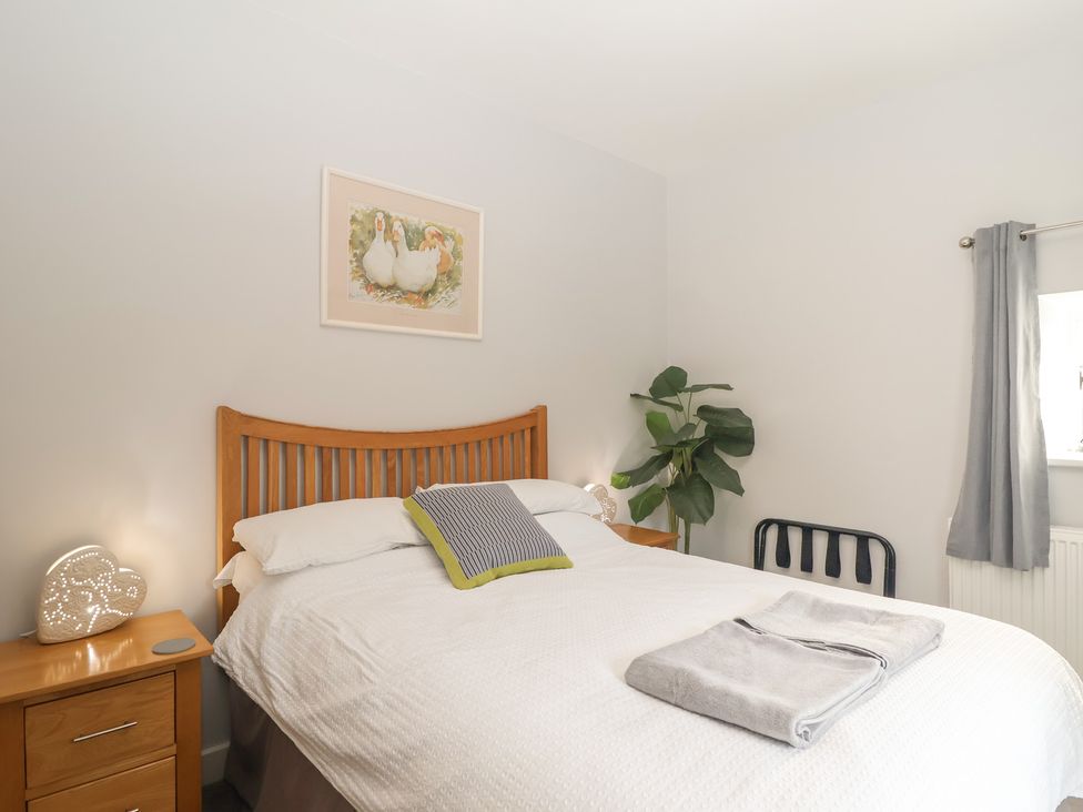 A bedroom with a bed and bedside table at The Old Dairy near Liskeard