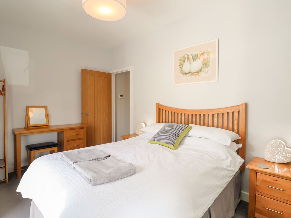 A bedroom with a bed and dresser at The Old Dairy near Liskeard