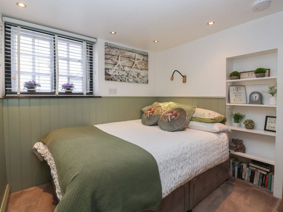 A bedroom with a bed and shelves at Cathedral Mews in Ripon