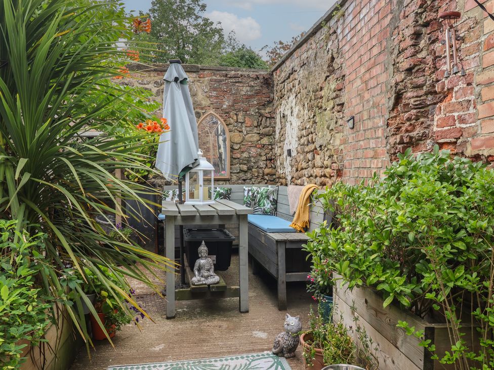 A garden with a table and bench at Cathedral Mews in Ripon