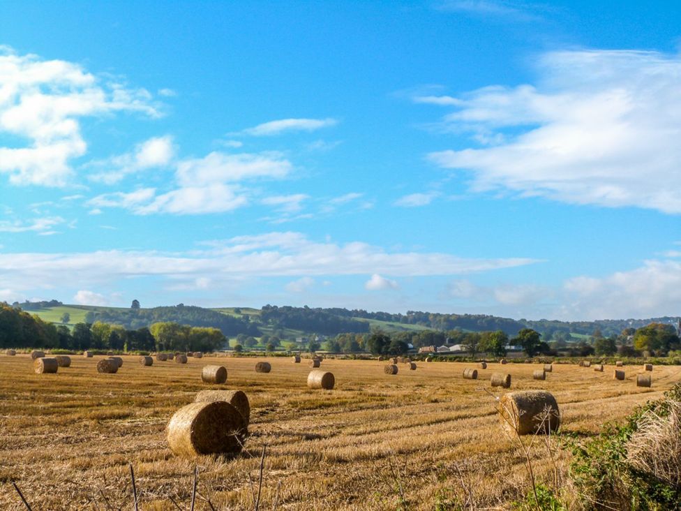 A field with hay bales and hills at Old Cottages: 1 bed Ripon