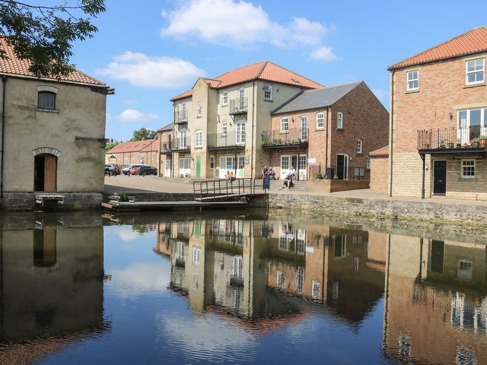 A view of houses and a bridge over water at Old Cottages: 1 bed in Ripon
