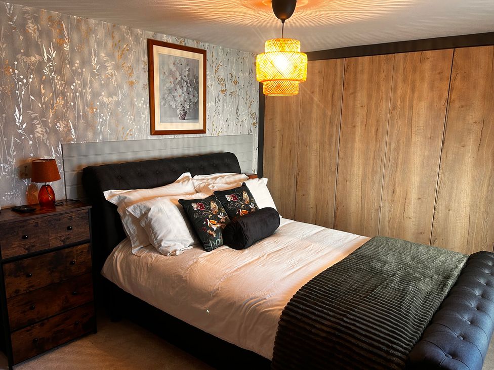A bedroom with a bed and a bedside table at Old Cottages: 3 Bed Ripon