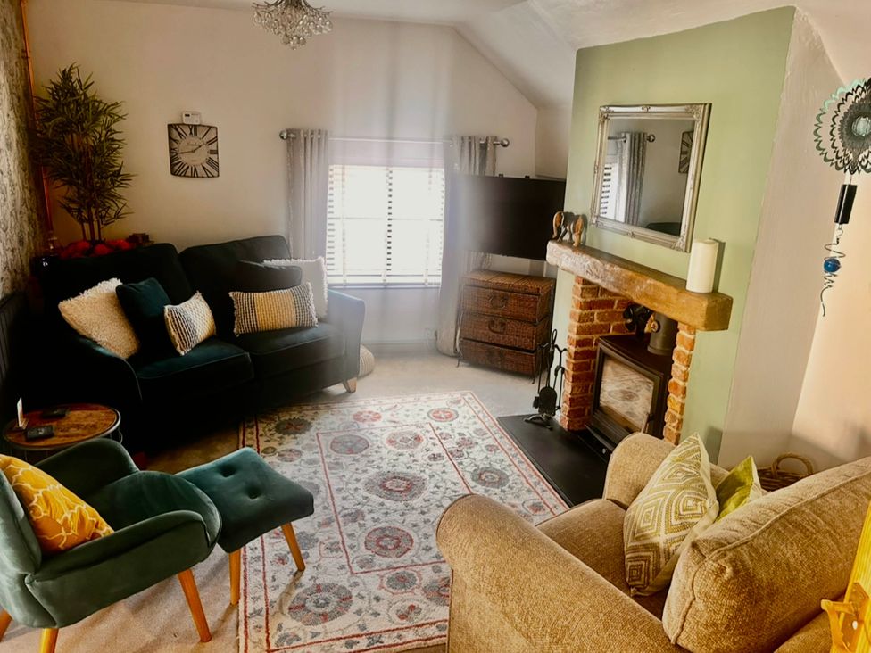 A living room with a sofa, armchair and fireplace at Old Cottages: 3 Bed in Ripon