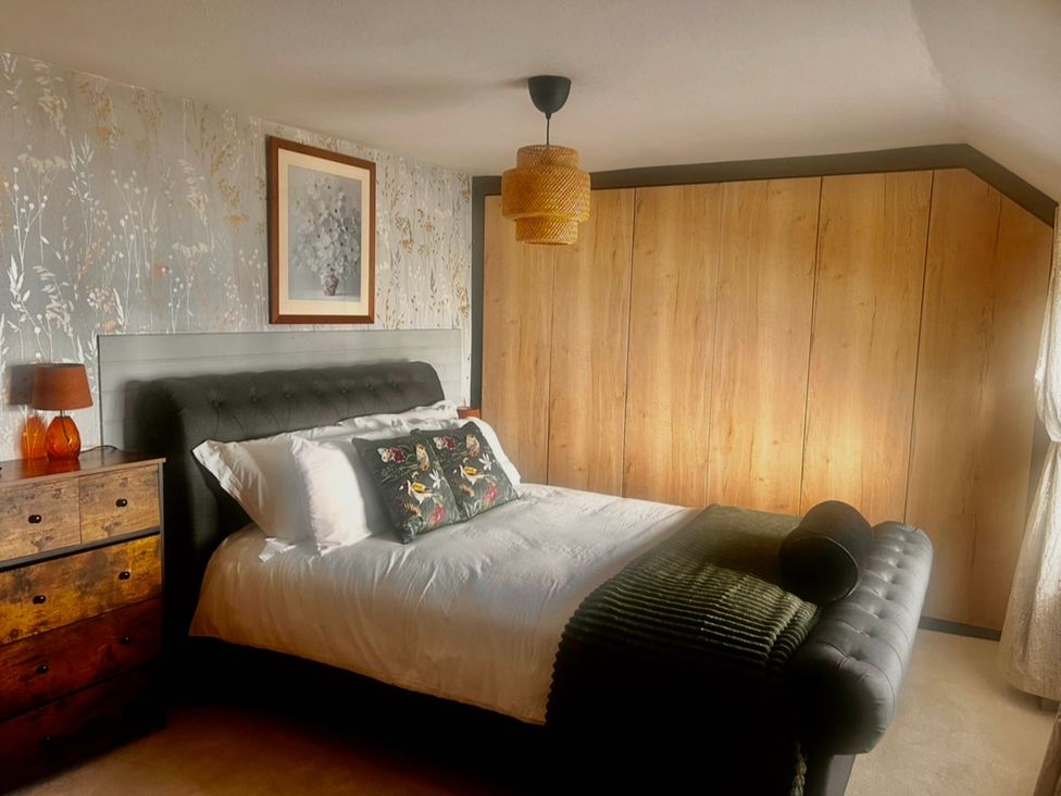 A bedroom with a bed and nightstand at Old Cottages: 3 Bed, Ripon