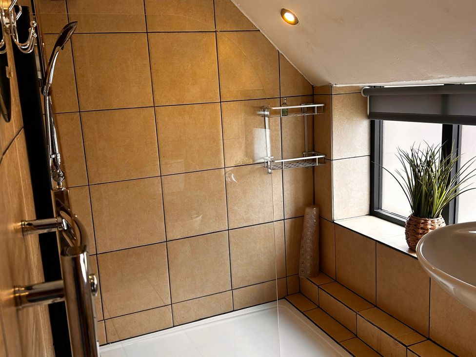 A bathroom with a shower and sink at Old Cottages: 3 Bed in Ripon