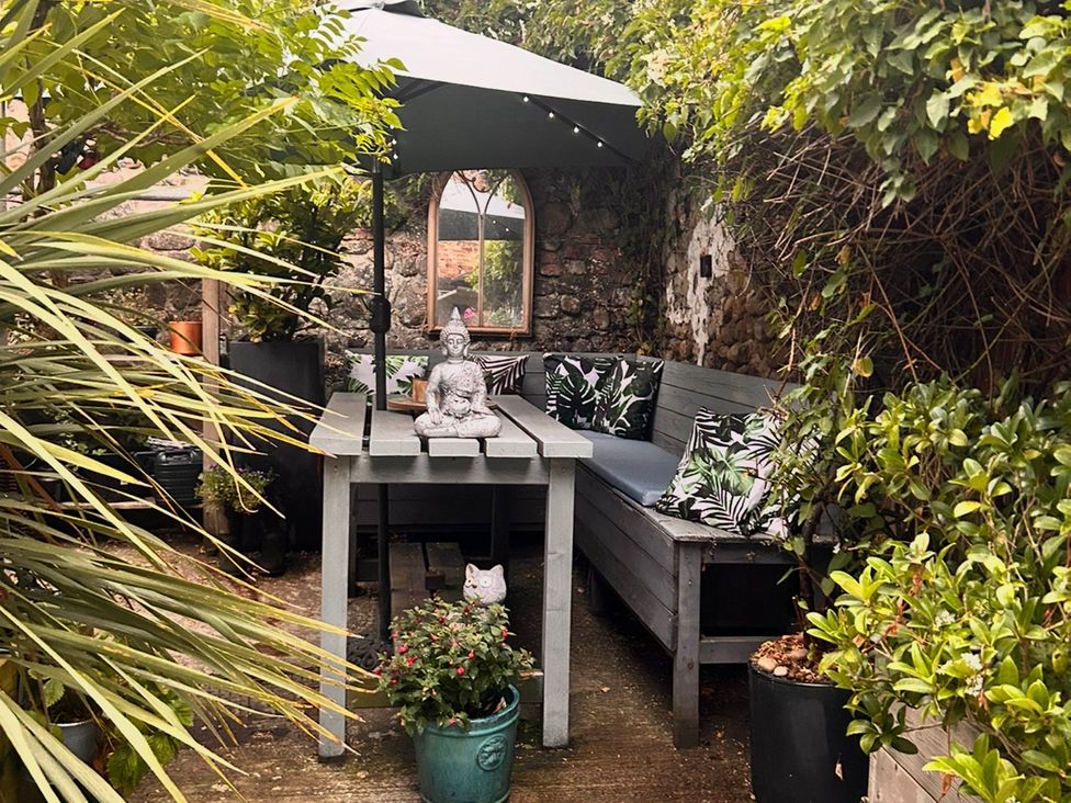 A garden with a table and bench seating at Old Cottages: 3 Bed, Ripon