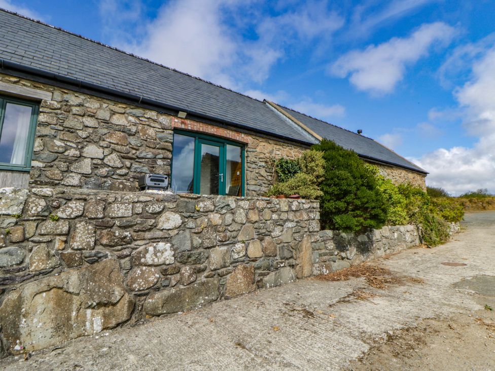 An outdoor area with a stone wall and window at May Cottage St Davids
