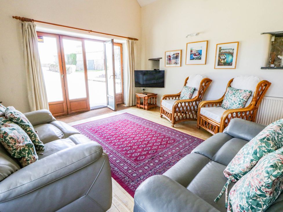 A living room with a sofa and armchairs at May Cottage in St Davids