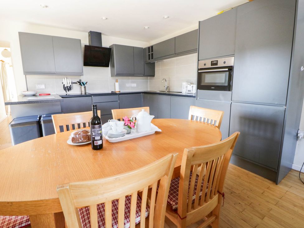 A kitchen with a table and chairs at May Cottage St Davids