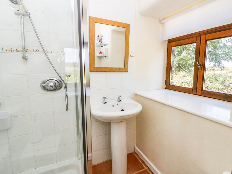 A bathroom with a sink and shower at May Cottage in St Davids