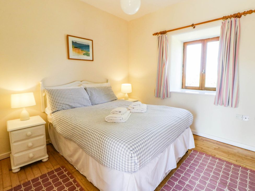 A bedroom with a bed and window at May Cottage St Davids