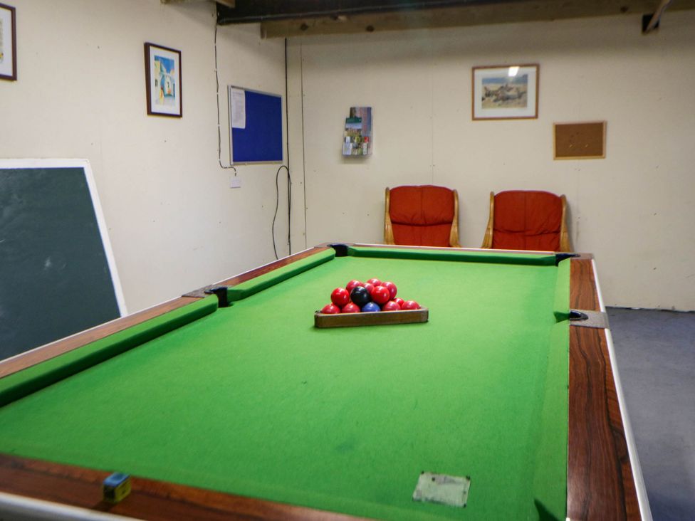 A games room with a pool table and chairs at May Cottage St Davids