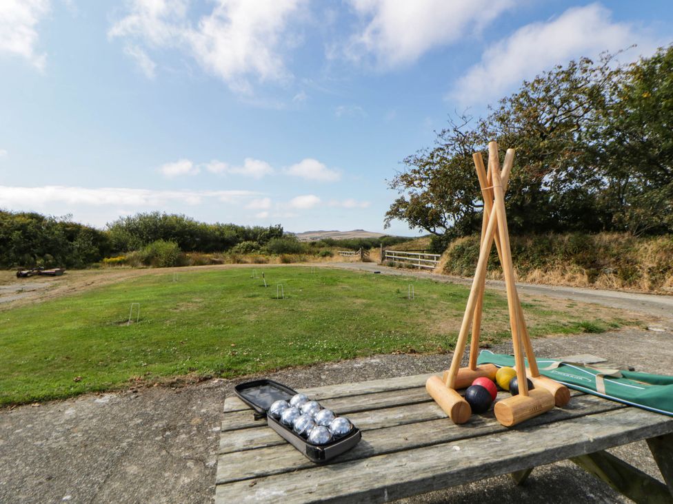 A croquet setup with mallets and balls on a table in an outdoor area at May Cottage St Davids