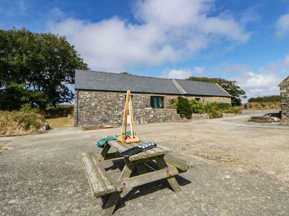 An outdoor area with a picnic table and stone buildings at May Cottage St Davids