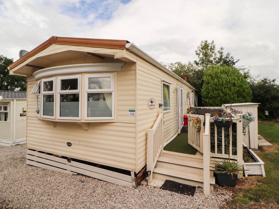 A mobile home with steps and planters at Summer Breeze in Clitheroe