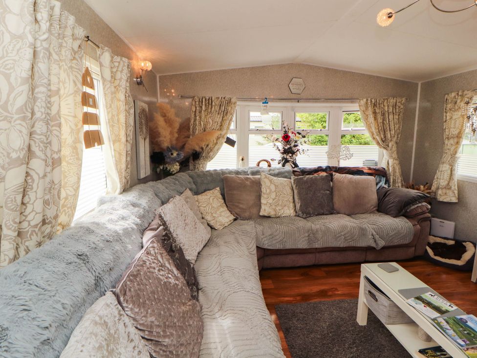 A living room with a sectional sofa and a coffee table at Summer Breeze in Clitheroe