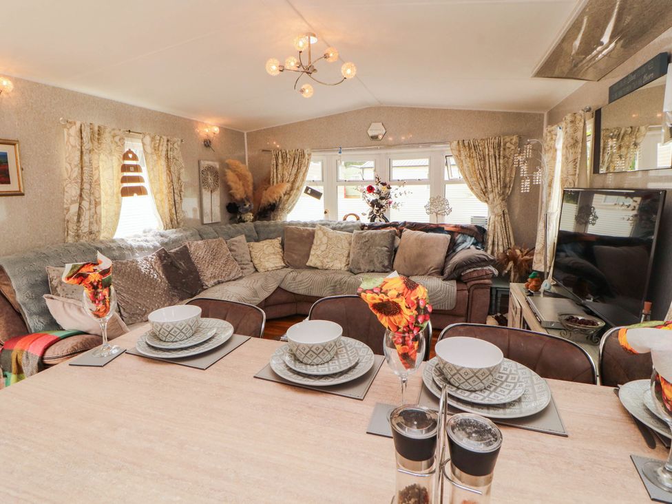 A living room with a sofa and dining table at Summer Breeze in Clitheroe