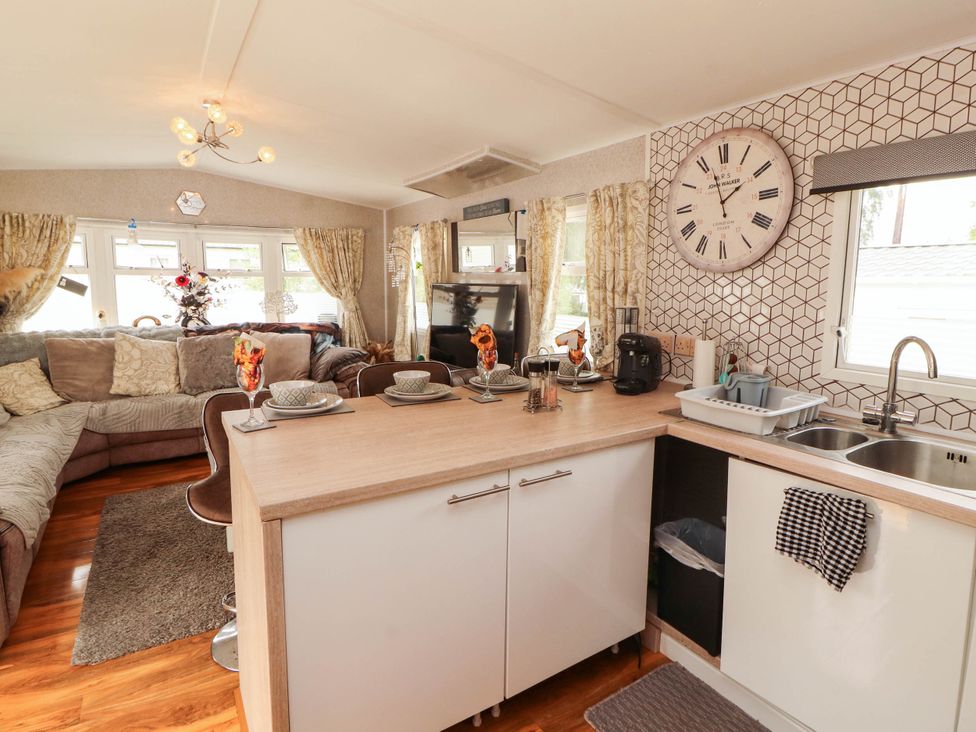 A kitchen with a sofa and television at Summer Breeze in Clitheroe