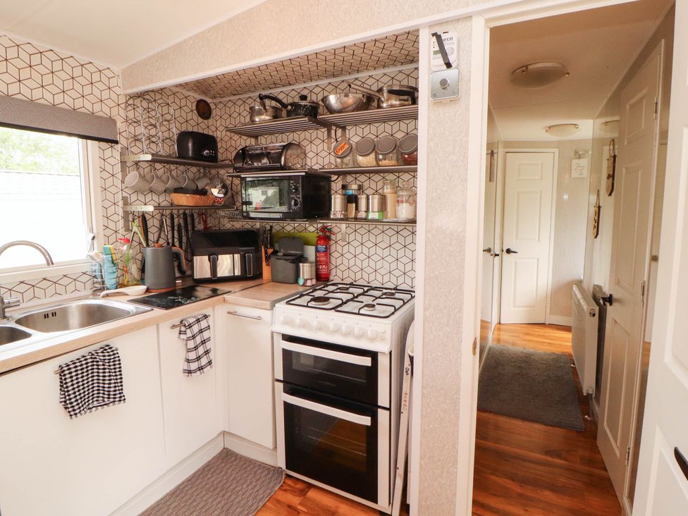 A kitchen with appliances and shelves at Summer Breeze in Clitheroe