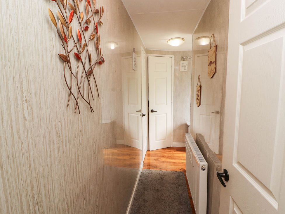 A hallway with a decorative wall art and doors at Summer Breeze in Clitheroe