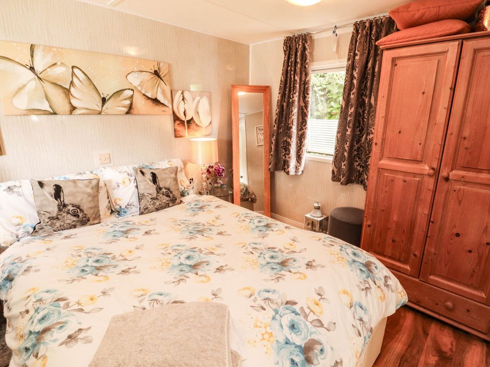 A bedroom with a bed and wardrobe at Summer Breeze in Clitheroe