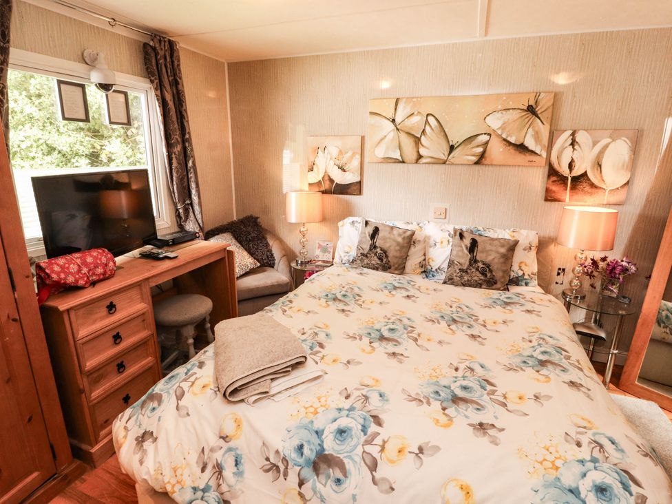A bedroom with a double bed and television at Summer Breeze in Clitheroe