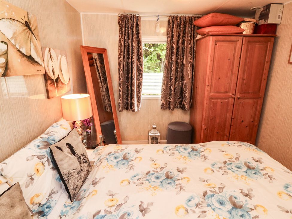 A bedroom with a bed and wardrobe at Summer Breeze in Clitheroe